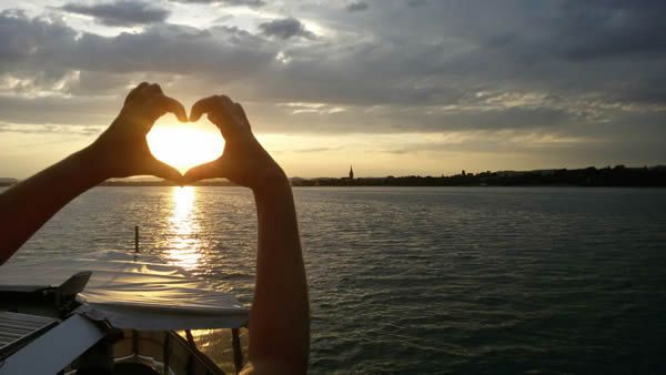 Bild von als Herz geformzen Händen im Sonnenuntergang